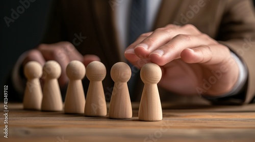The concept of leadership in business  with a strong leader leading a team to success  using their power and assurance  holding wooden figures to represent their professional and innovative ideas.