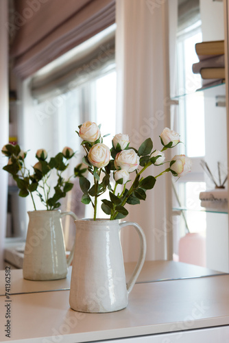 Bouquet of flowers in a vase in front of a mirror in the bedroom. Interior details. © Olena Svechkova