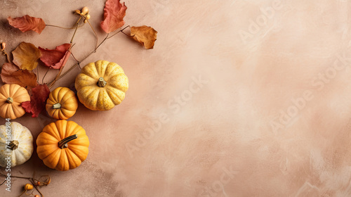 A group of pumpkins with dried autumn leaves and twig, on a blush color marble