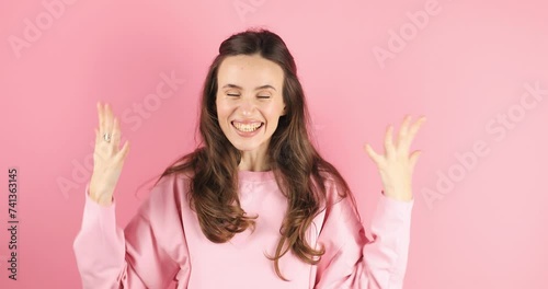 Excited sport fan young woman in pink long sleeves wait for special moment go celebrate win scream rejoices doing winner hands gesture at last isolated on pink color wall background. photo