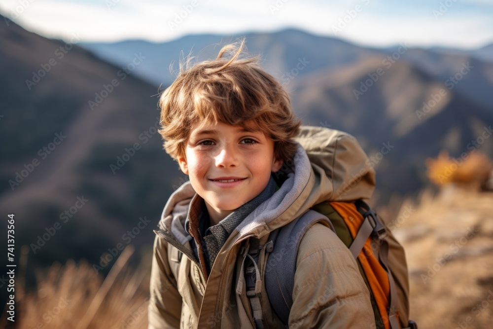 Portrait of a boy with a backpack on the background of mountains.