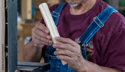 Senior carpenter man working with wood in carpentry woodworking place