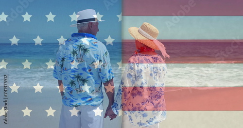 Image of flag of usa over diverse senior couple on beach in summer