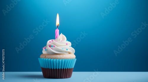 Birthday cupcake with one candle and a blue background