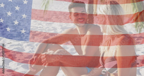 Image of american flag waving over smiling couple in love on beach