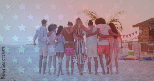 Multiple blinking stars against rear view of group of friends dancing on the beach