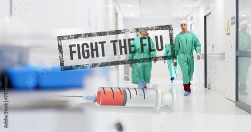 Image of fight the flue text and syringe over diverse surgeons in hospital