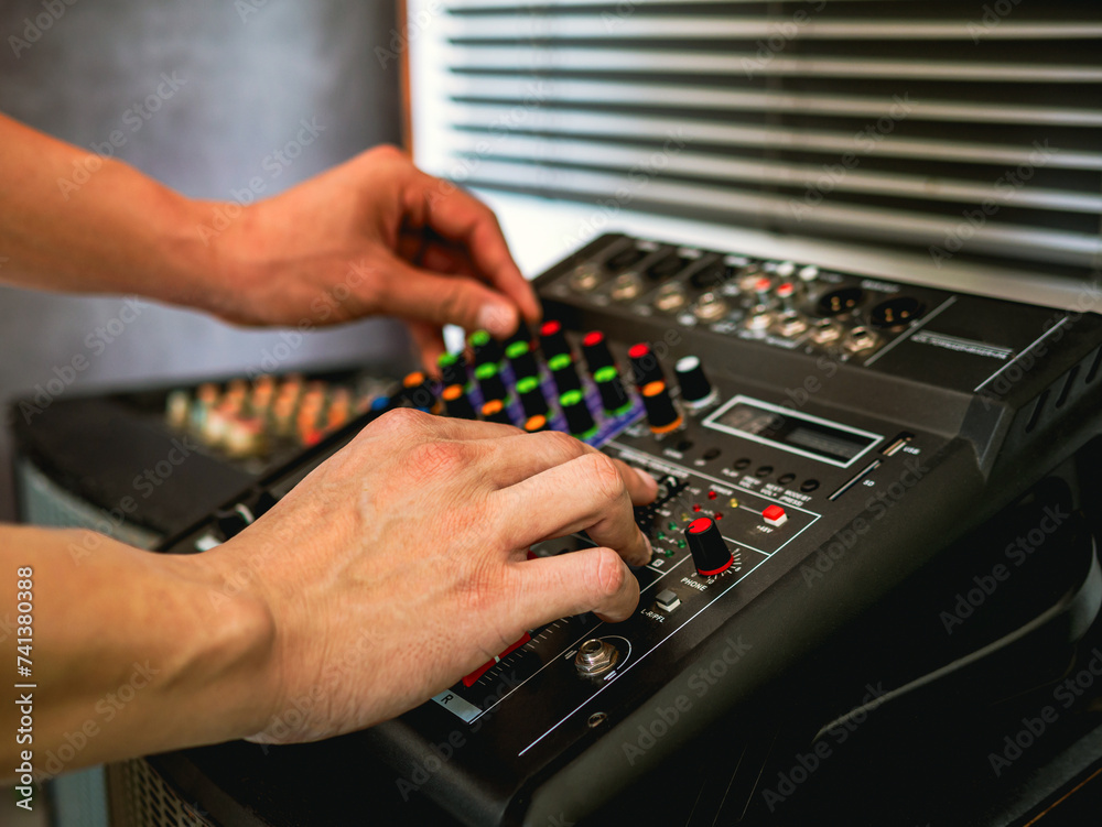 Close-up of sound engineer hands adjusting control sound mixer in recording, broadcasting studio,Sound mixer. Professional audio mixing console, buttons, faders and sliders. sound check. Close-up of sound engineer hands adjusting control sound mixer in recording, broadcasting studio,Sound mixer. Professional audio mixing console, buttons, faders and sliders. sound check.