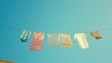 Clothes hanging on a line against a clear blue sky capture the freshness of laundry day, perfect for domestic life and cleanliness themes, with space for text.