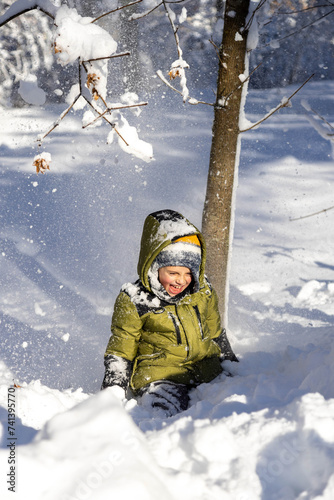 little boy playing in winter forest