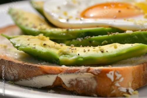 closeup of an openface sandwich with sliced avocado and egg photo