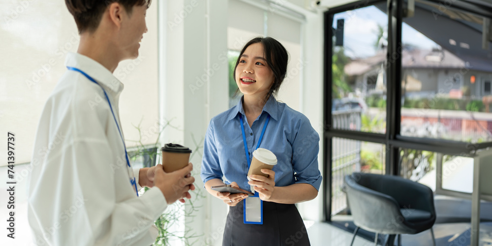 Two happy business people team asian discussing new project at workplace during coffee break in office Two happy business people team asian discussing new project at workplace during coffee break in office
