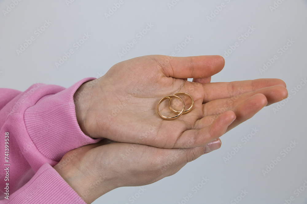 Wedding gold rings are held in the palms