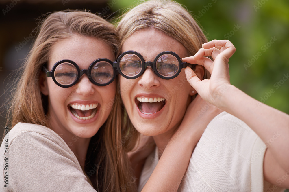 Φωτογραφία Women, mother and daughter with funny glasses in garden for comic joke, laughing and hug in portrait
