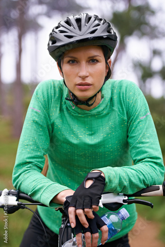 Nature, cardio and portrait of woman with bicycle for fitness in an outdoor park training for race or marathon. Sport, exercise and female athlete cyclist riding bike for workout in field or forest.