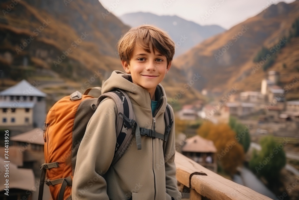 Portrait of a boy with backpack on the background of the mountains