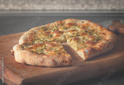 Pizza with suluguni olives. Pizza knife on a wooden board photo