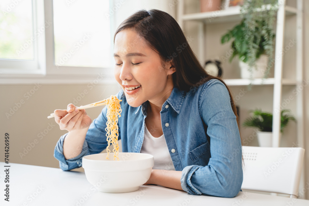 Young female eating instant noodle isolated on background. Young female eating instant noodle isolated on background.