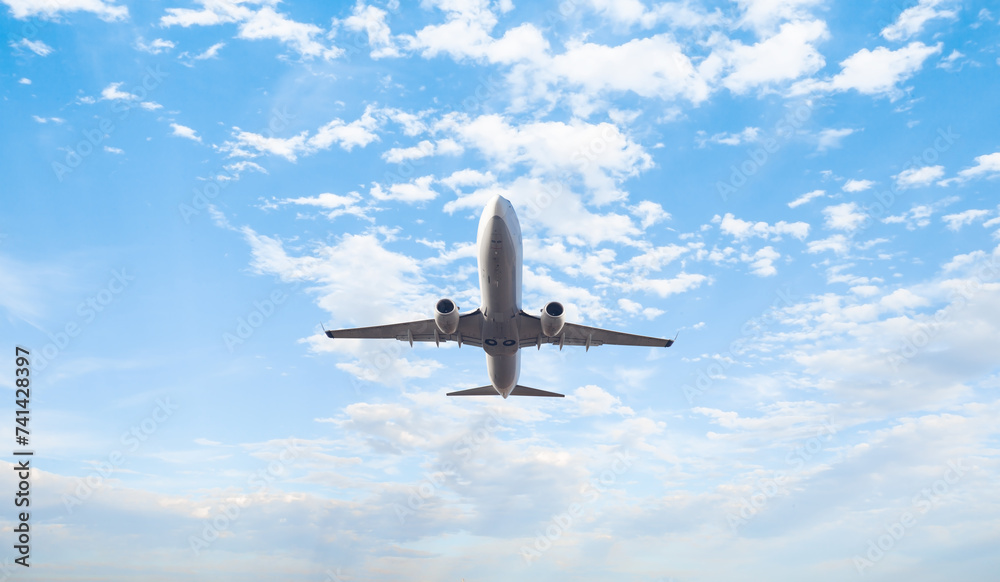 Obraz premium White passenger airplane flying in the sky amazing clouds in the background - Travel by air transport