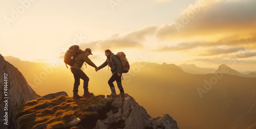 Climbers help friends reach the top of a mountain