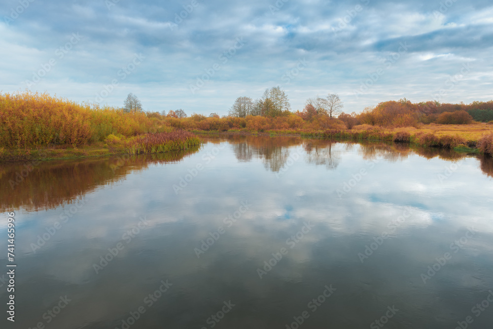 Beautiful autumn landscape with beautiful reflection of the sky and plants in the river
