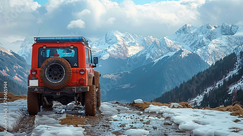A red 4x4 offroad vehicle on a muddy, snowy trail, set against snow-capped mountains under a cloudy sky, encapsulating the essence of adventure. © Valeriy