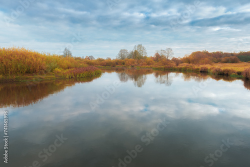 Beautiful autumn landscape with beautiful reflection of the sky and plants in the river