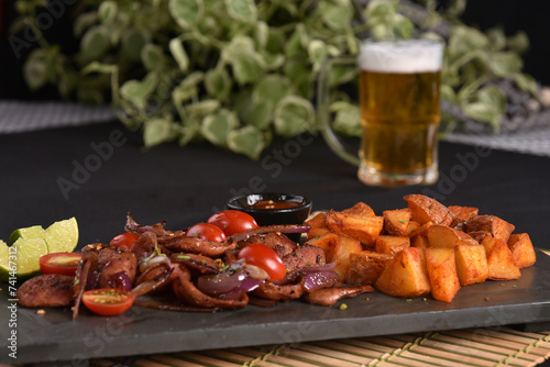 portion of fried Calabrian sausage with onion and roasted potatoes with spices and paprika photo