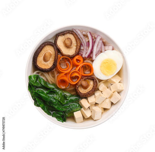 Delicious vegetarian ramen with egg, mushrooms, tofu and vegetables in bowl isolated on white, top view. Noodle soup