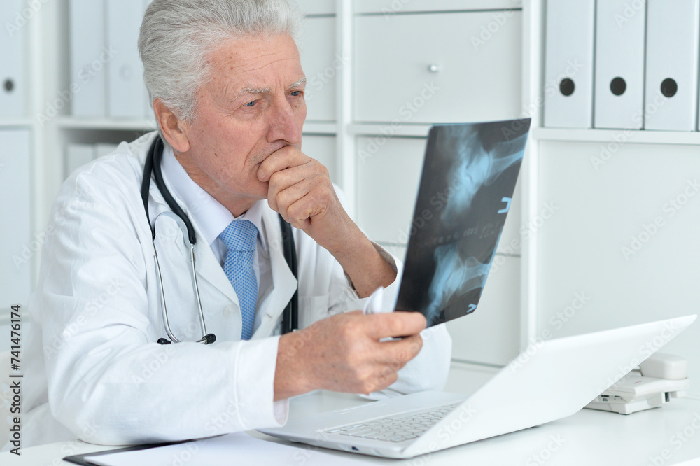 Portrait of sad senior male doctor with x-ray