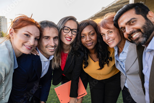 Multiracial group of businesspeople taking a selfie together with coworkers in the office after finishing brainstorming photo