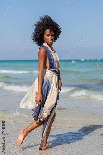 A beautiful black woman in a flowing dress.