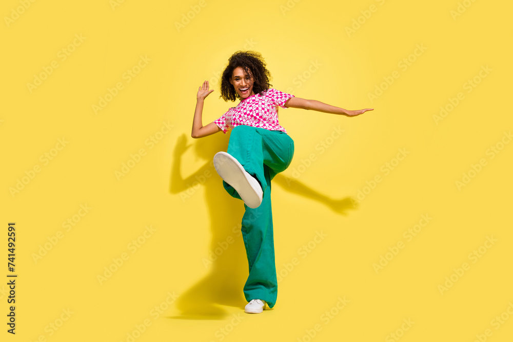 Full body portrait of crazy cheerful lady dance leg kick shoe sole empty space isolated on yellow color background