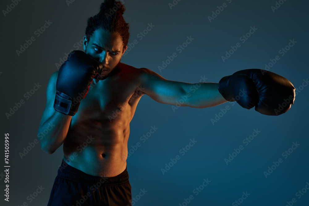 appealing young african american man in black shorts with boxing gloves training actively in gym