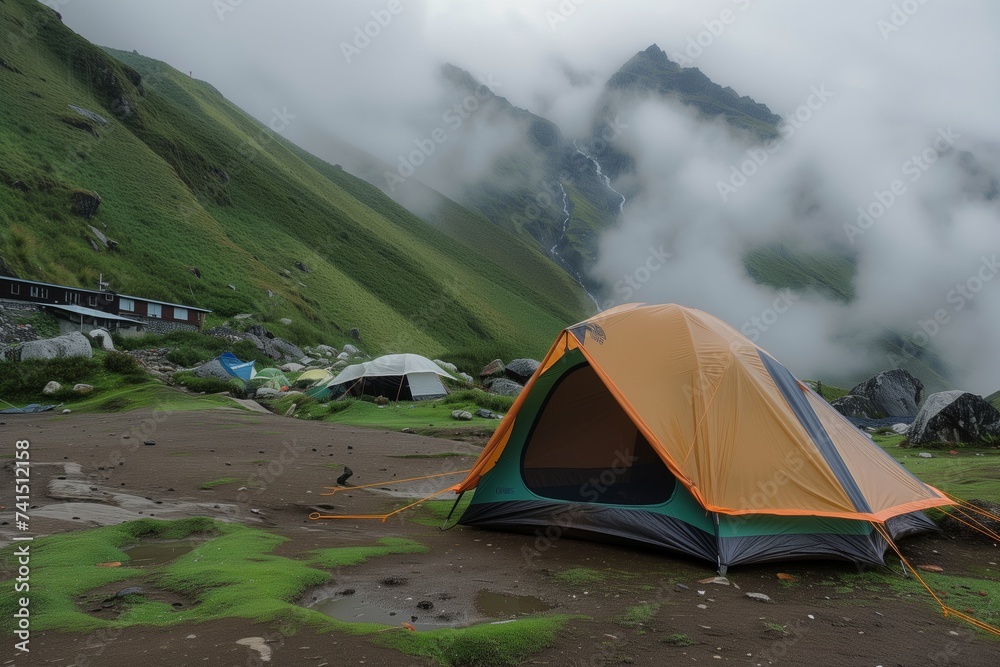 tent at mountain base with rain mist swirling around