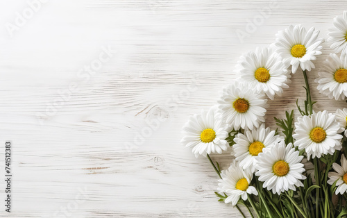 a bouquet of garden camomile flowers on a white wooden table.