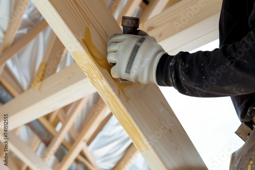 man sealing timber frame joints against weather photo