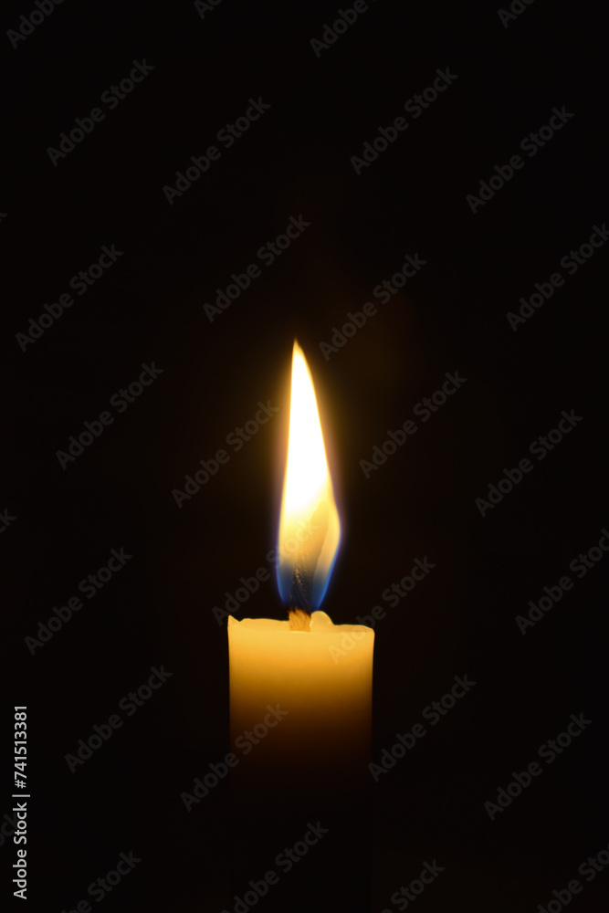 Single Candle with flame in the dark place, isolated black background Single Candle with flame in the dark place, isolated black background