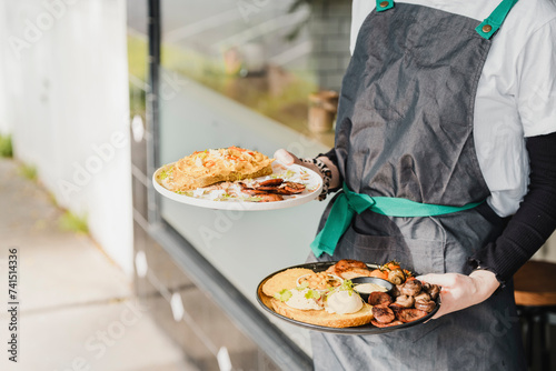 Unrecognizable waiter serving English brunch in a trendy cafe of Australia
