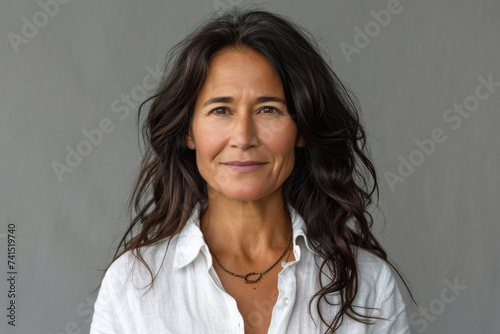 Happy attractive confident European woman of middle age posing for beauty portrait. Beautiful mid aged mature lady smiling on background, attractive female model looking at camera. Close up face .