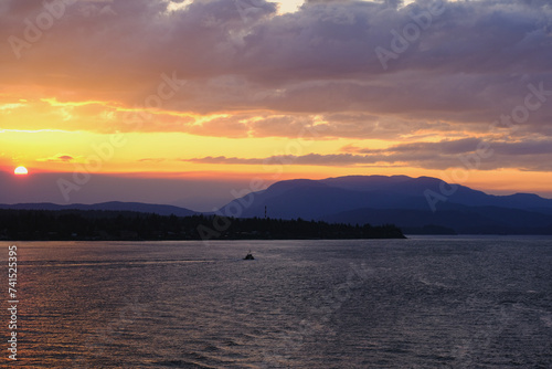 Panoramic sunrise or sunset landscape nature coastal scenery with beautiful fire sky and dramatic cloudscapes in Alaska Inside Passage glacier mountain range view
