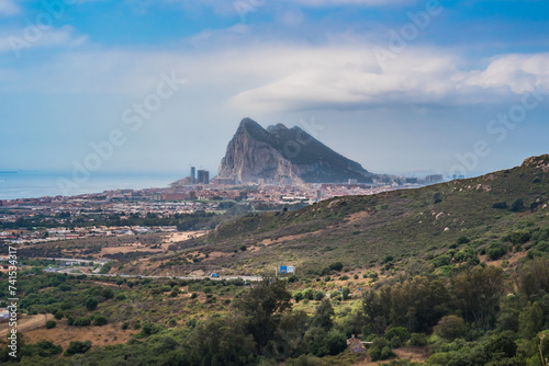 Viewpoint to hill along highway with architecture of La Línea de la Concepción with fog and headland of The Rock Gibraltar on the horizon, SPAIN photo