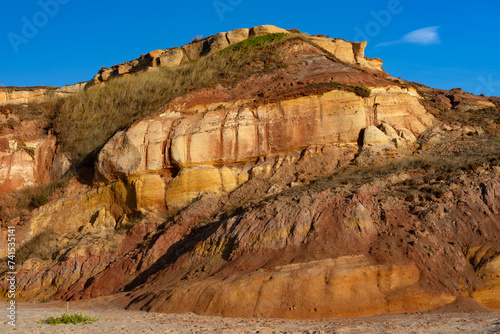 Multicolored sandstone rocks in the Almagreira beach in the Peniche area of the Center region of Portugal at sunset. photo