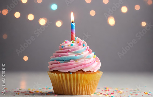 Birthday cupcake with a candle, pink cream and festive tinsel decoration on bright background with copy space. Generated AI 