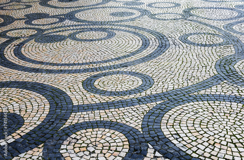 Calçada portuguesa com desenhos feitos de pedras negras e pedras brancas