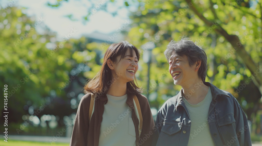 Obraz premium 日本人の若いカップルが新緑のきれいな公園を散歩している仲睦まじい様子