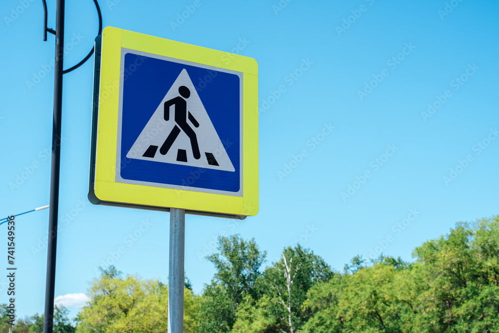 Pedestrian crossing sign on blue sky background