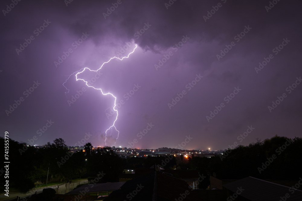 Fototapeta premium Stunning lightning strikes just before an incredible thunderstorm over a suburban home area. Showing the absolute strength that exists within nature