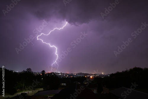 Stunning lightning strikes just before an incredible thunderstorm over a suburban home area. Showing the absolute strength that exists within nature