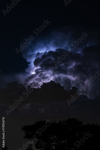 Beautiful cloud formation over a suburban home area with lightning striking within its self showing a very ominous scene. looks like lightning trying to escape out of the side. 